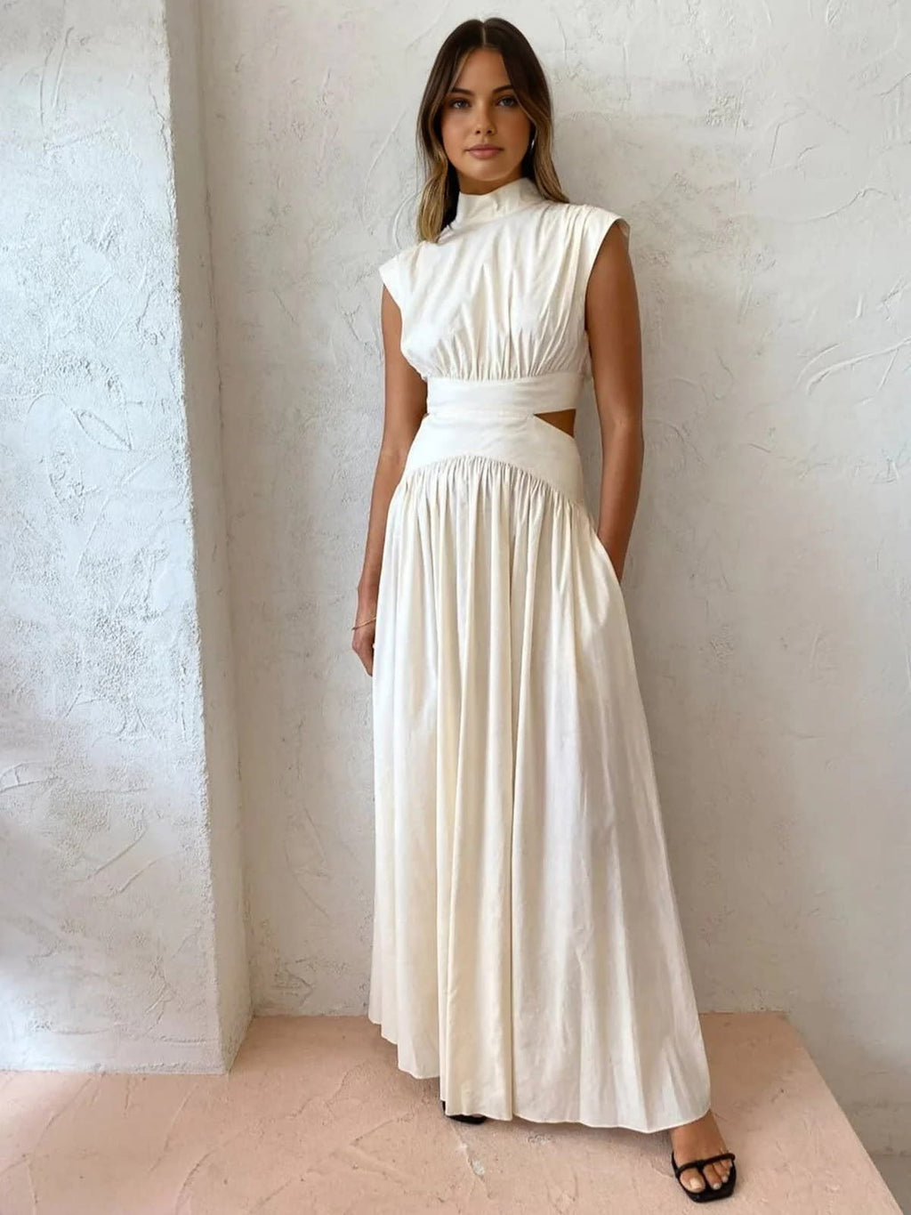 Sleeveless mock neck maxi dress with side cutouts and gathered skirt.