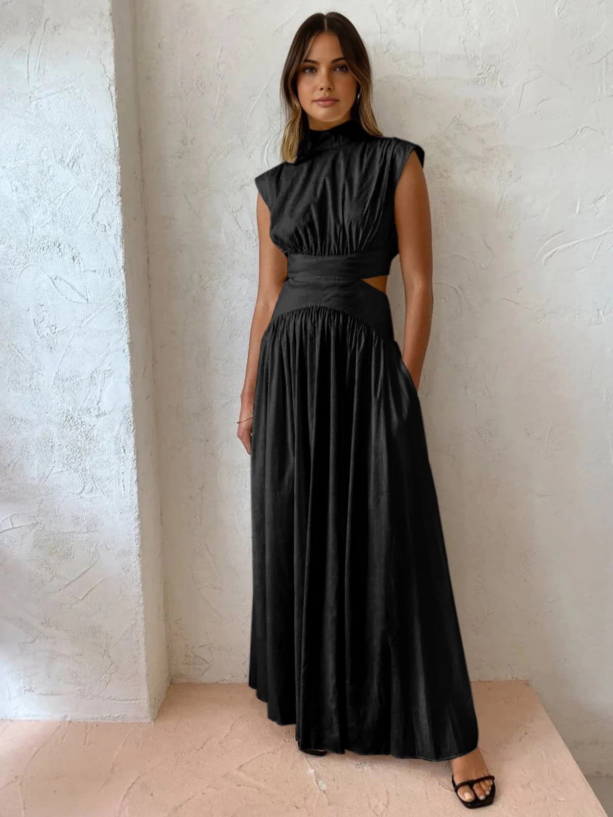 Sleeveless mock neck maxi dress with side cutouts and gathered skirt.