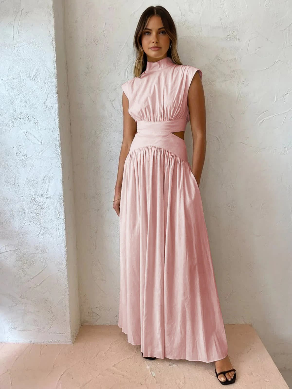 Sleeveless mock neck maxi dress with side cutouts and gathered skirt.