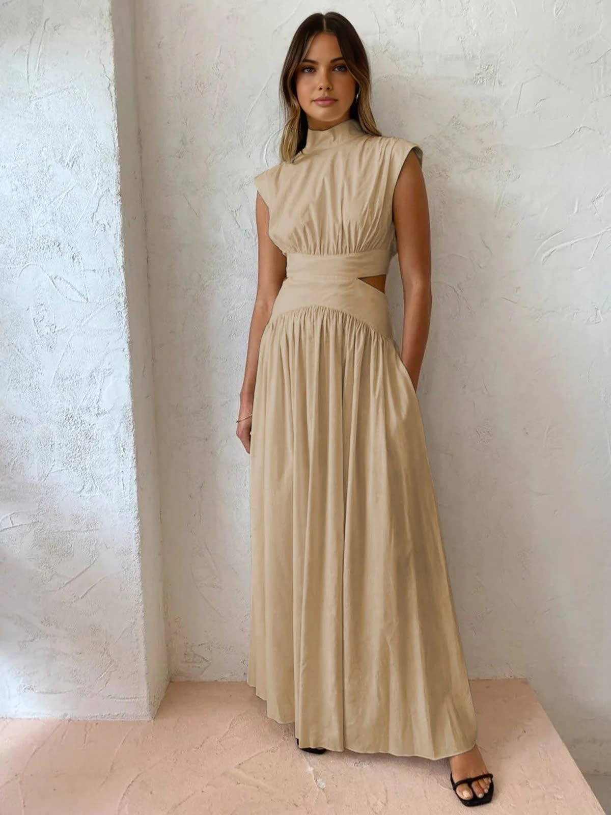 Sleeveless mock neck maxi dress with side cutouts and gathered skirt.