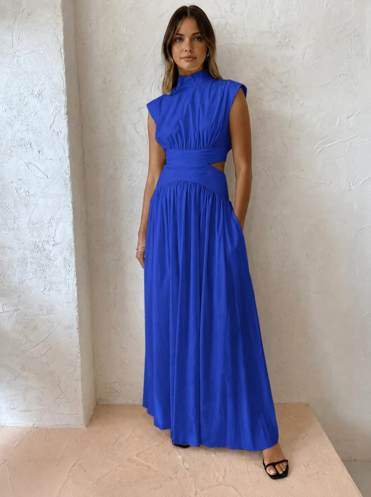 Sleeveless mock neck maxi dress with side cutouts and gathered skirt.