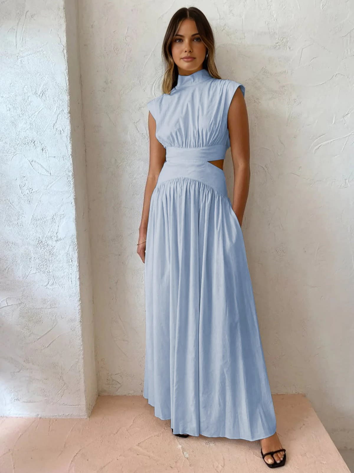 Sleeveless mock neck maxi dress with side cutouts and gathered skirt.