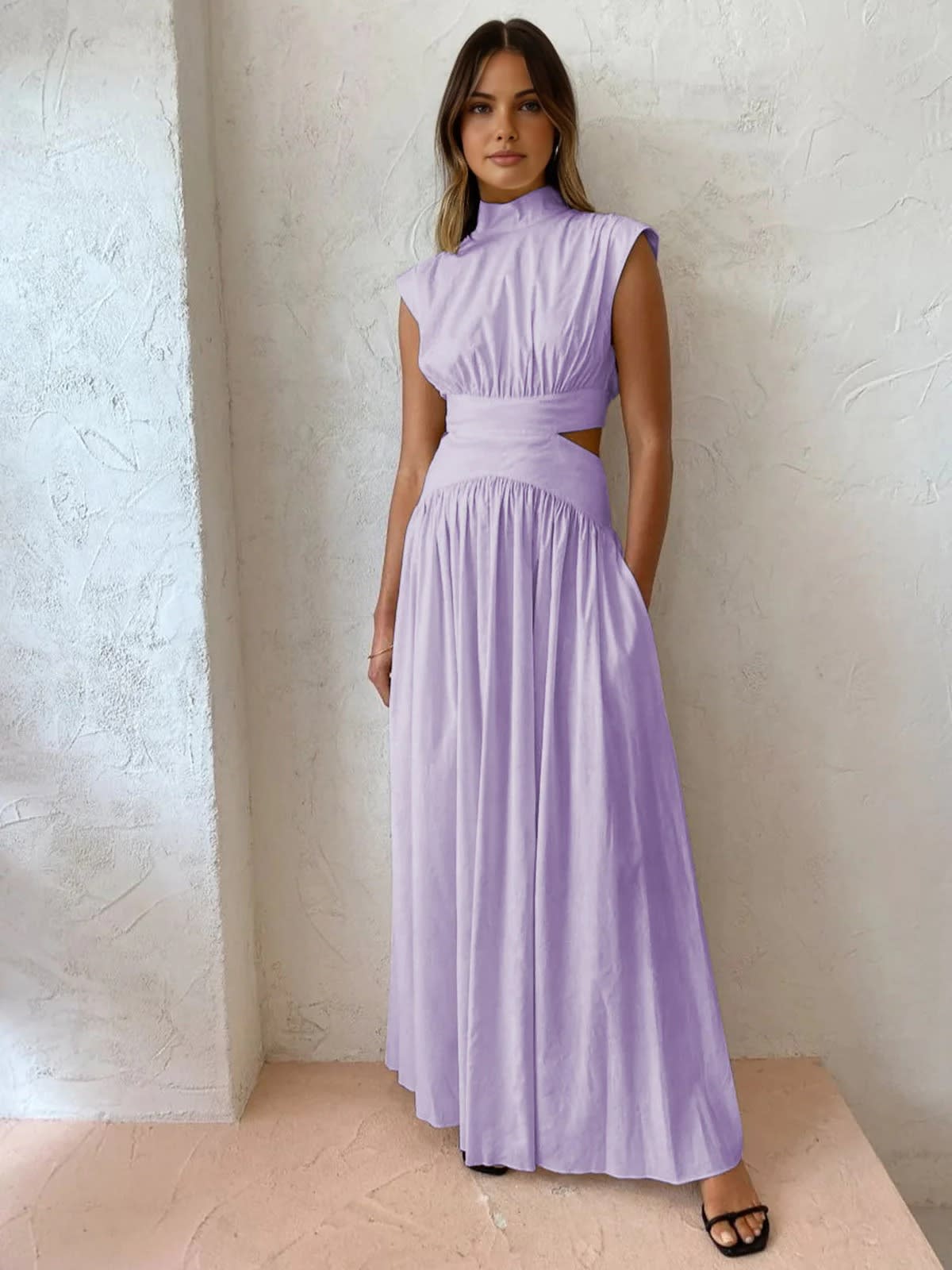 Sleeveless mock neck maxi dress with side cutouts and gathered skirt.