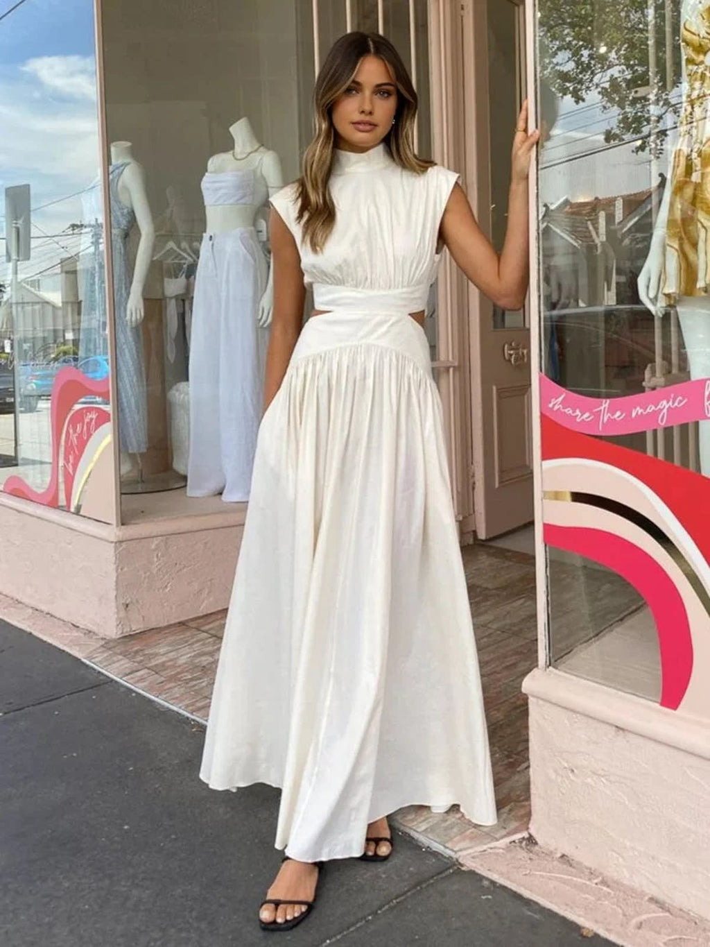 Sleeveless mock neck maxi dress with side cutouts and gathered skirt.