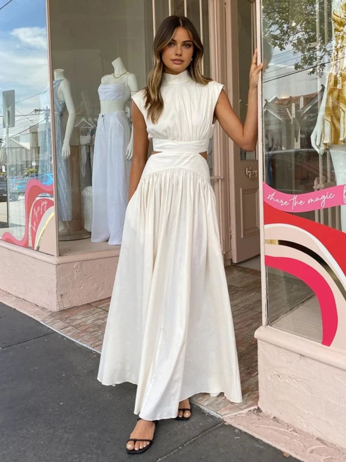 Sleeveless mock neck maxi dress with side cutouts and gathered skirt.