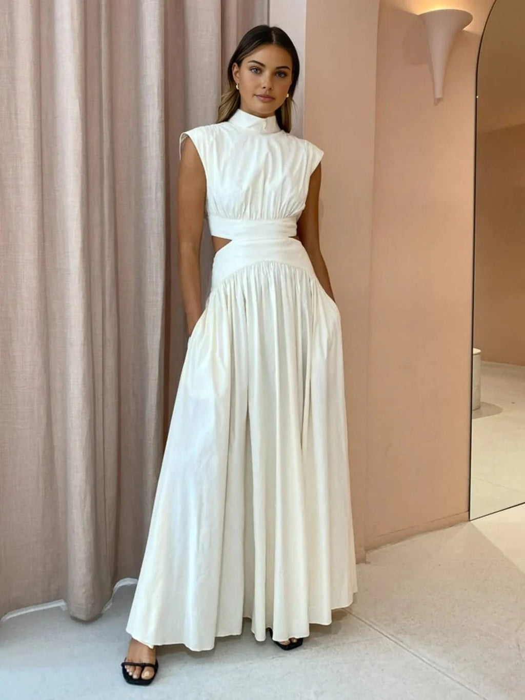 Sleeveless mock neck maxi dress with side cutouts and gathered skirt.