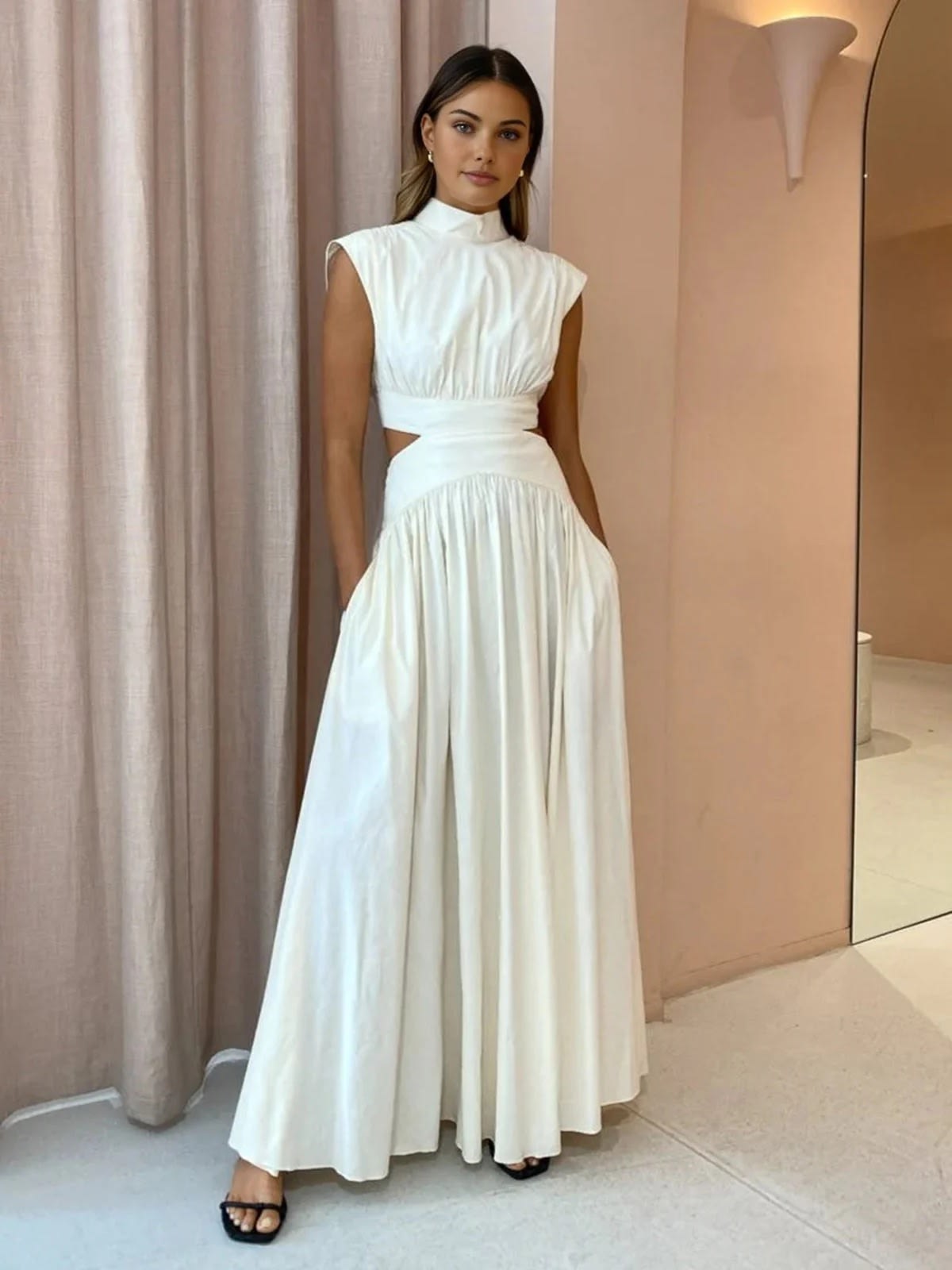 Sleeveless mock neck maxi dress with side cutouts and gathered skirt.