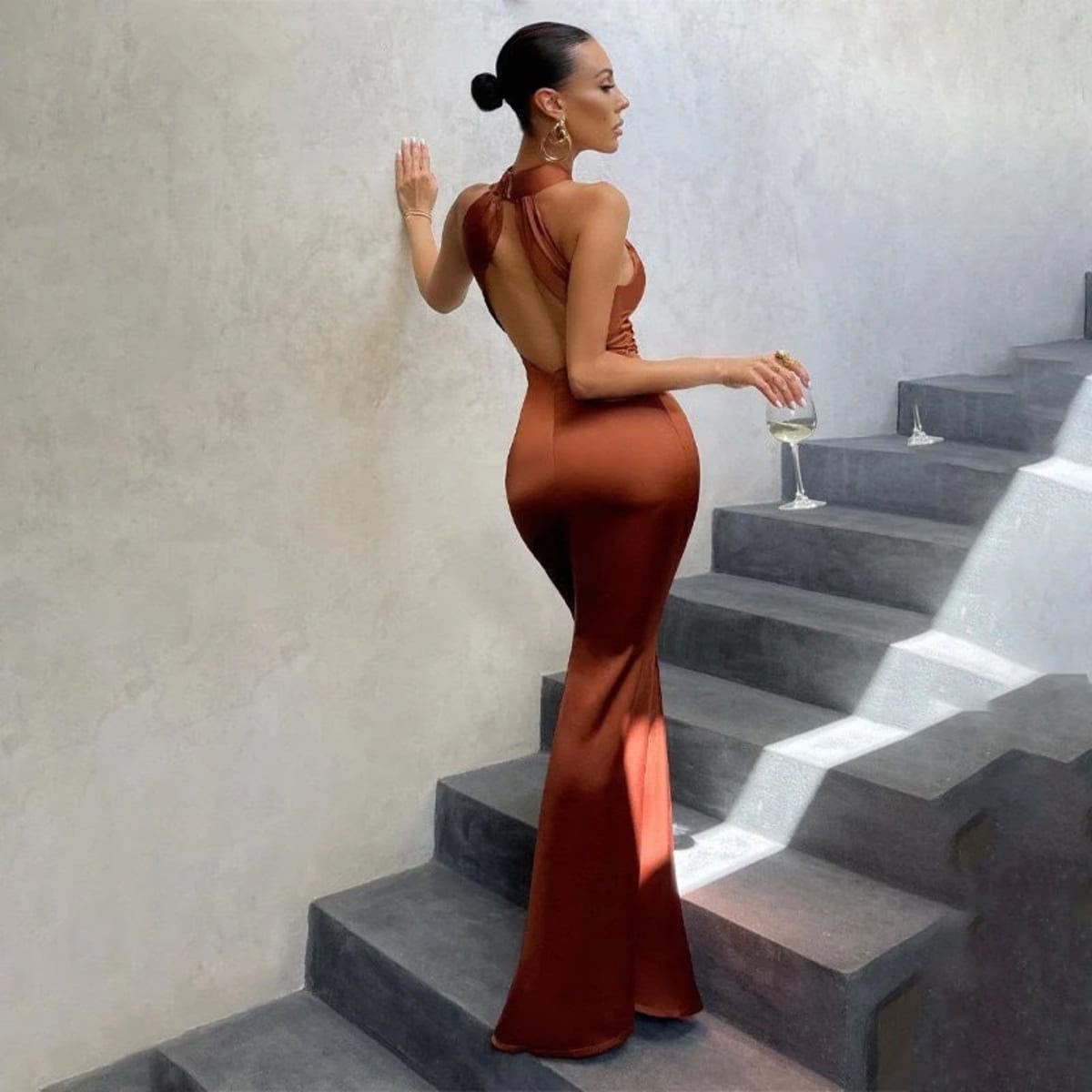 Fitted dress with open back and fishtail hem, formal wear.