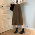 Model wearing high-waisted pleated A-line midi skirt with belt.