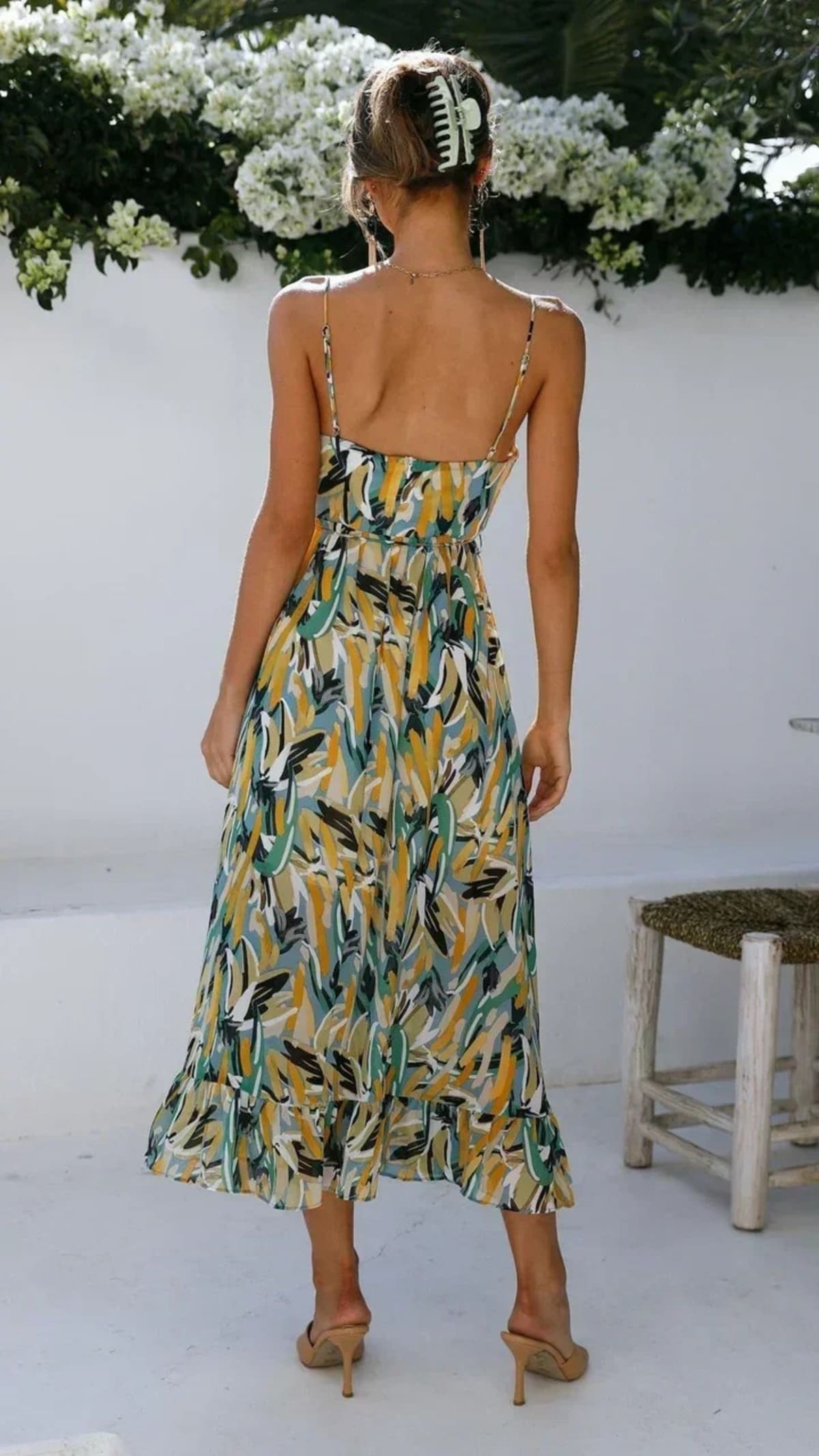 Woman wearing abstract printed midi dress with ruffle hem.