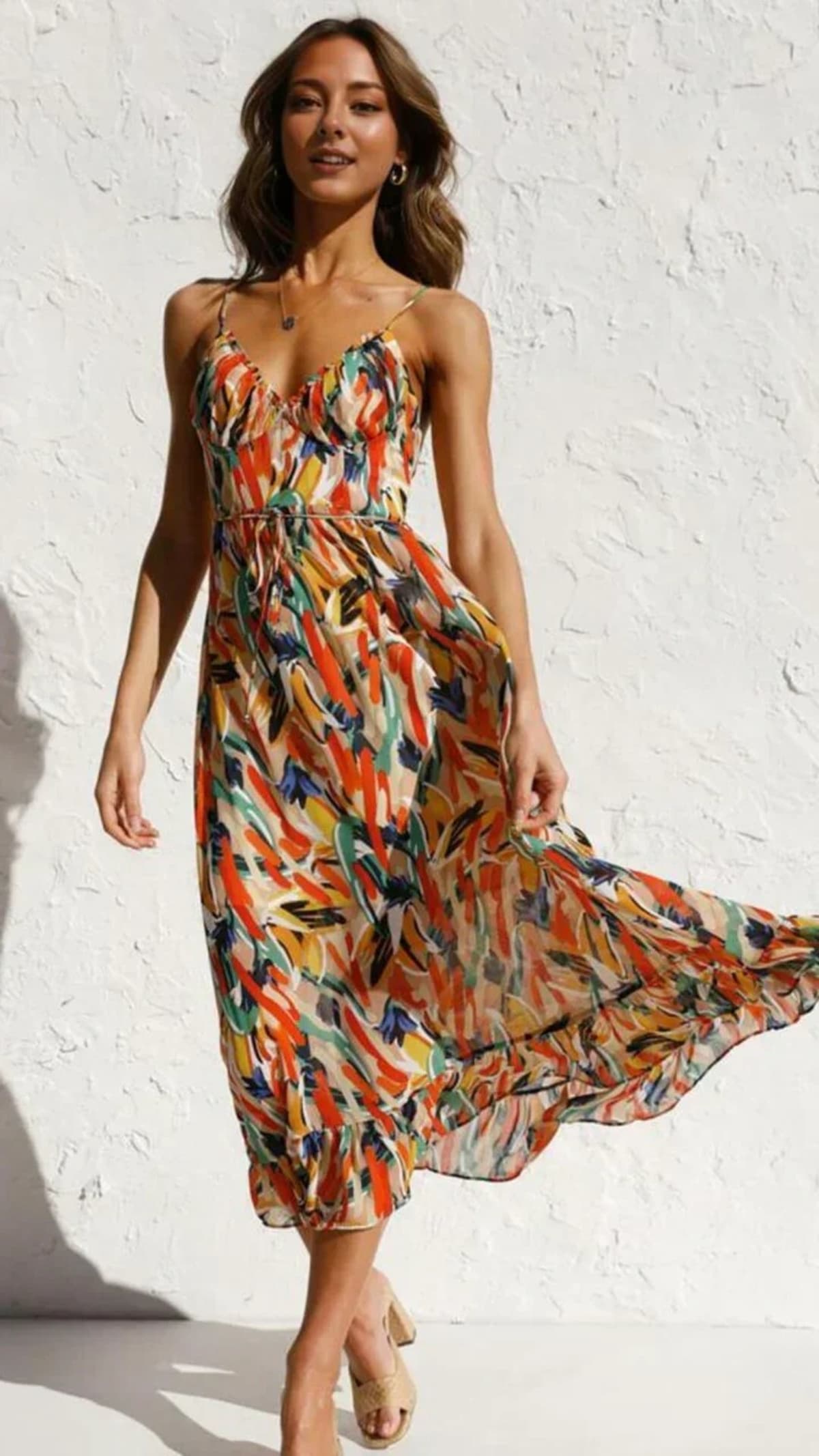 Woman wearing abstract printed midi dress with ruffle hem.