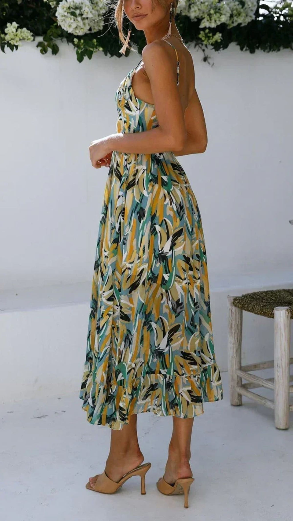 Woman wearing abstract printed midi dress with ruffle hem.