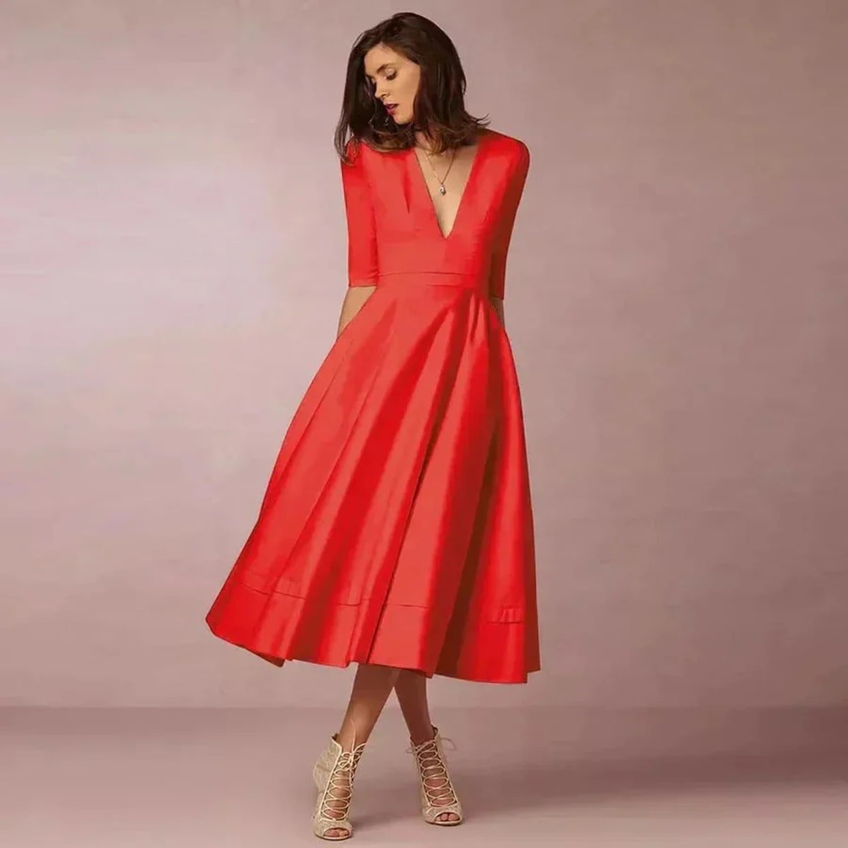 Woman in V-neck midi dress with 3/4 sleeves and pockets.