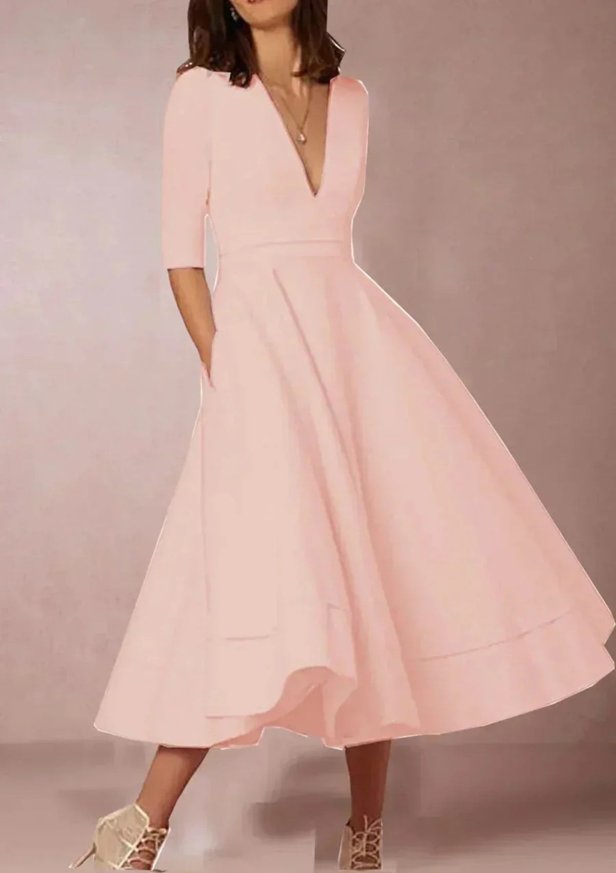Woman in V-neck midi dress with 3/4 sleeves and pockets.