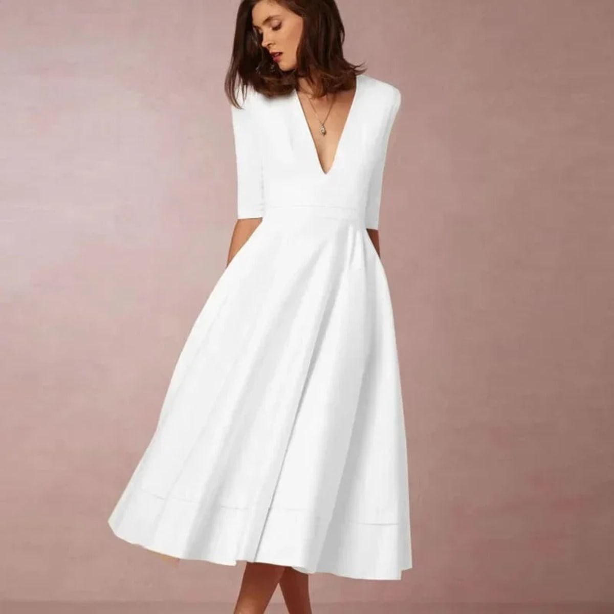 Woman in V-neck midi dress with 3/4 sleeves and pockets.