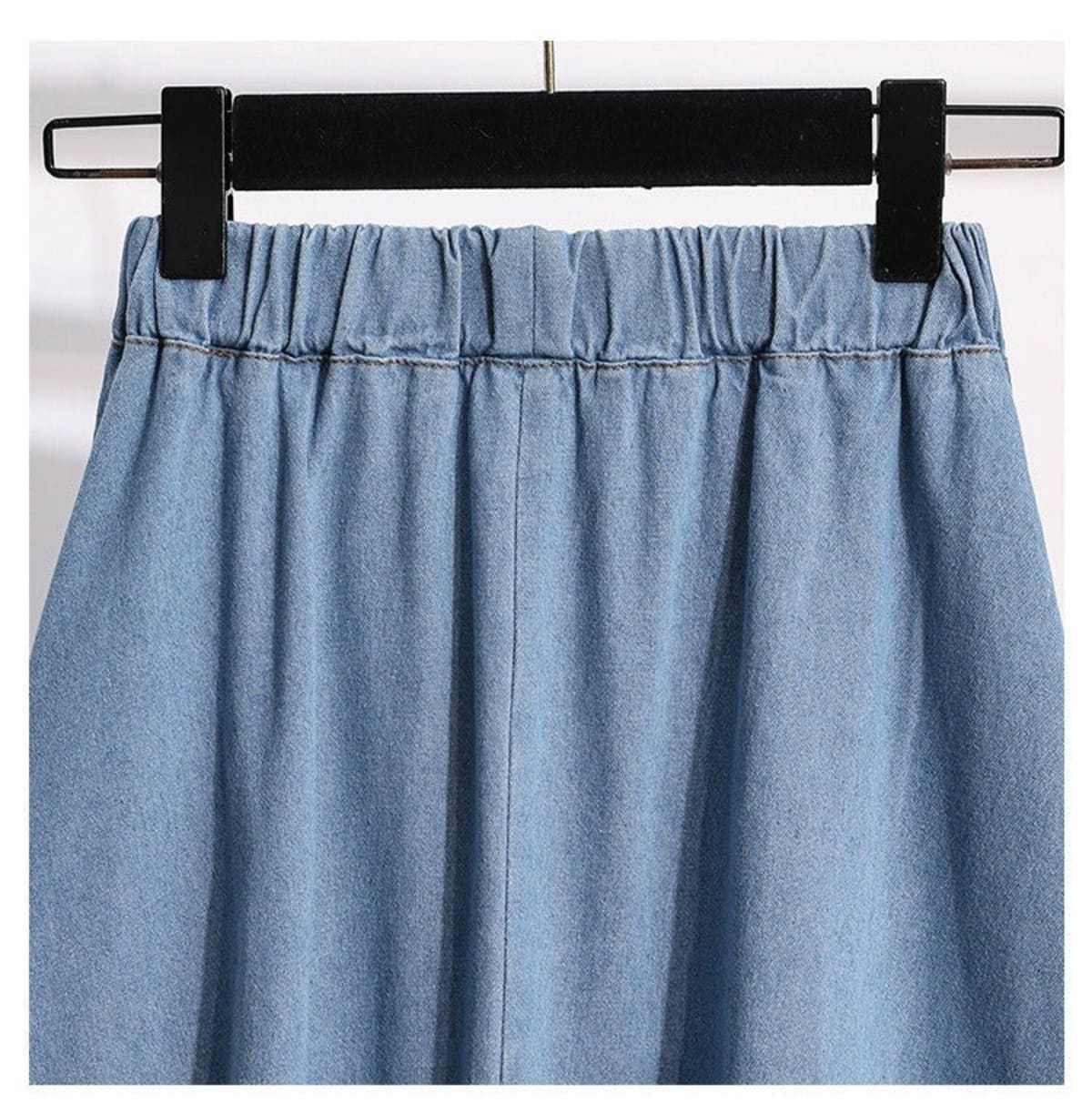 Light blue A-line midi skirt with button-front and elastic waist on hanger.