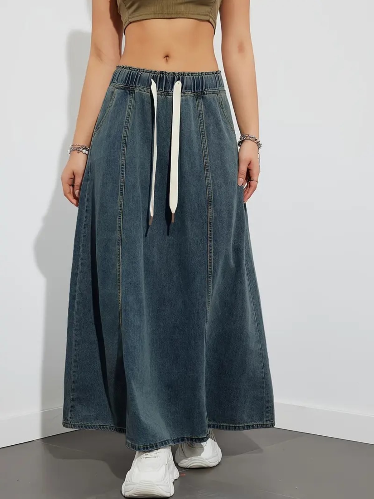 Person wearing a denim maxi skirt with elastic waist and drawstring.