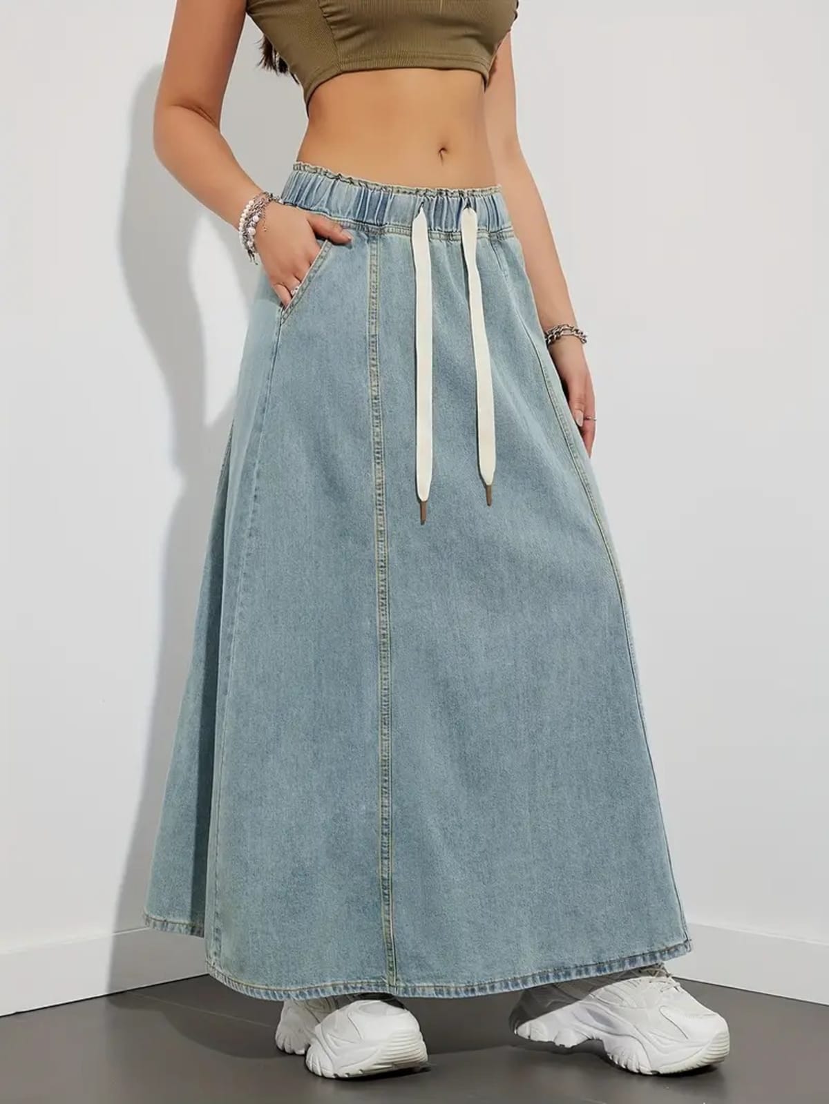 Person wearing a denim maxi skirt with elastic waist and drawstring.
