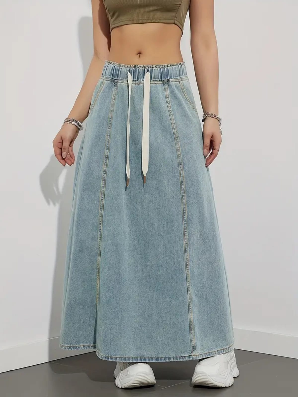 Person wearing a denim maxi skirt with elastic waist and drawstring.