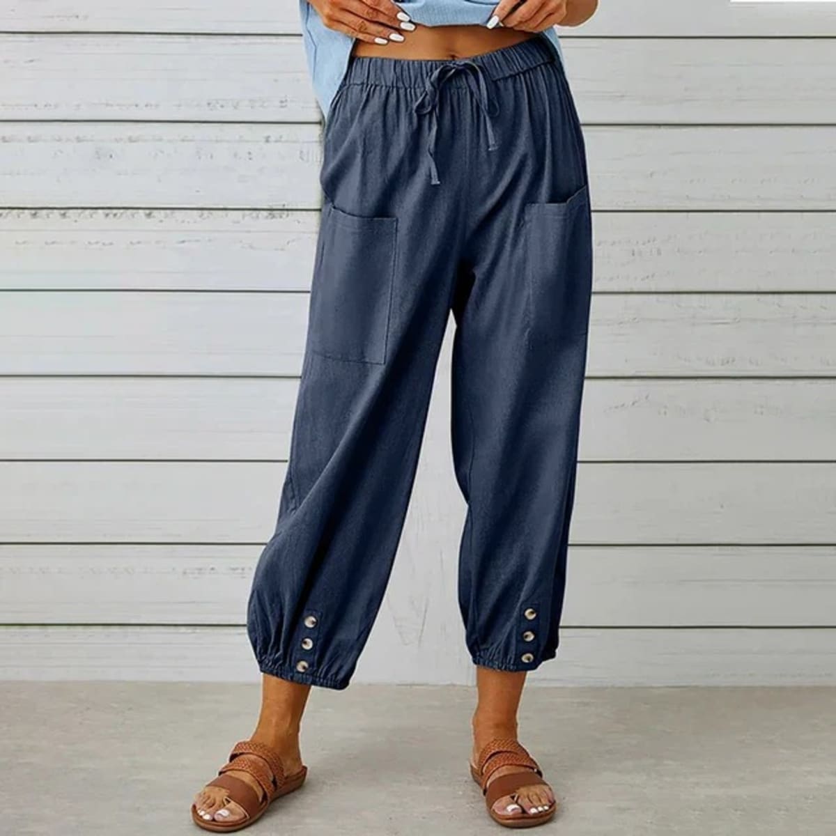 High-waisted relaxed pants with drawstring and ankle buttons.