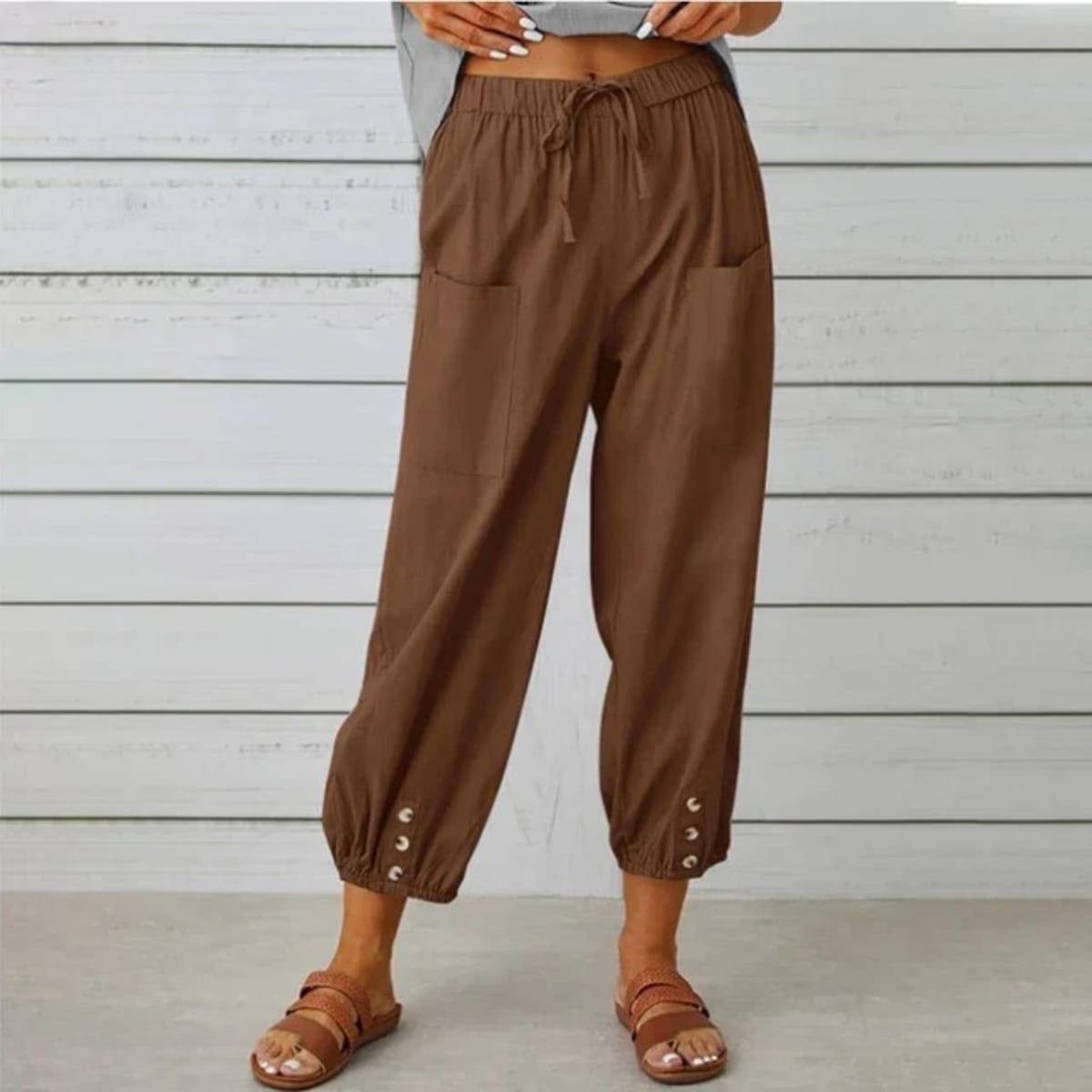 High-waisted relaxed pants with drawstring and ankle buttons.