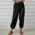 High-waisted relaxed pants with drawstring and ankle buttons.