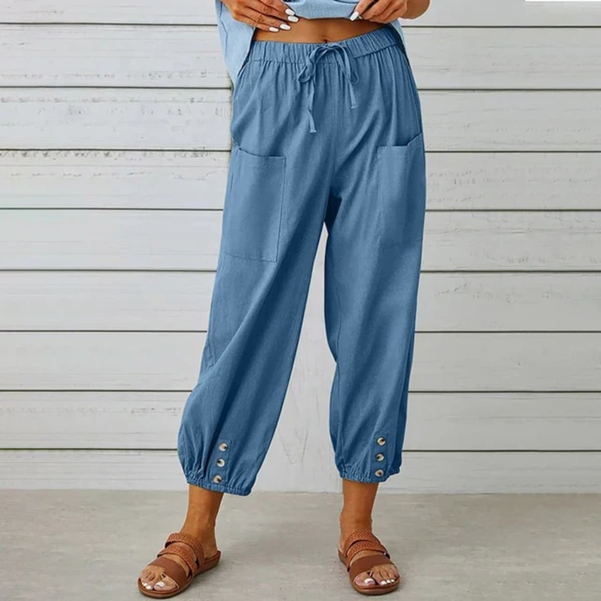 High-waisted relaxed pants with drawstring and ankle buttons.