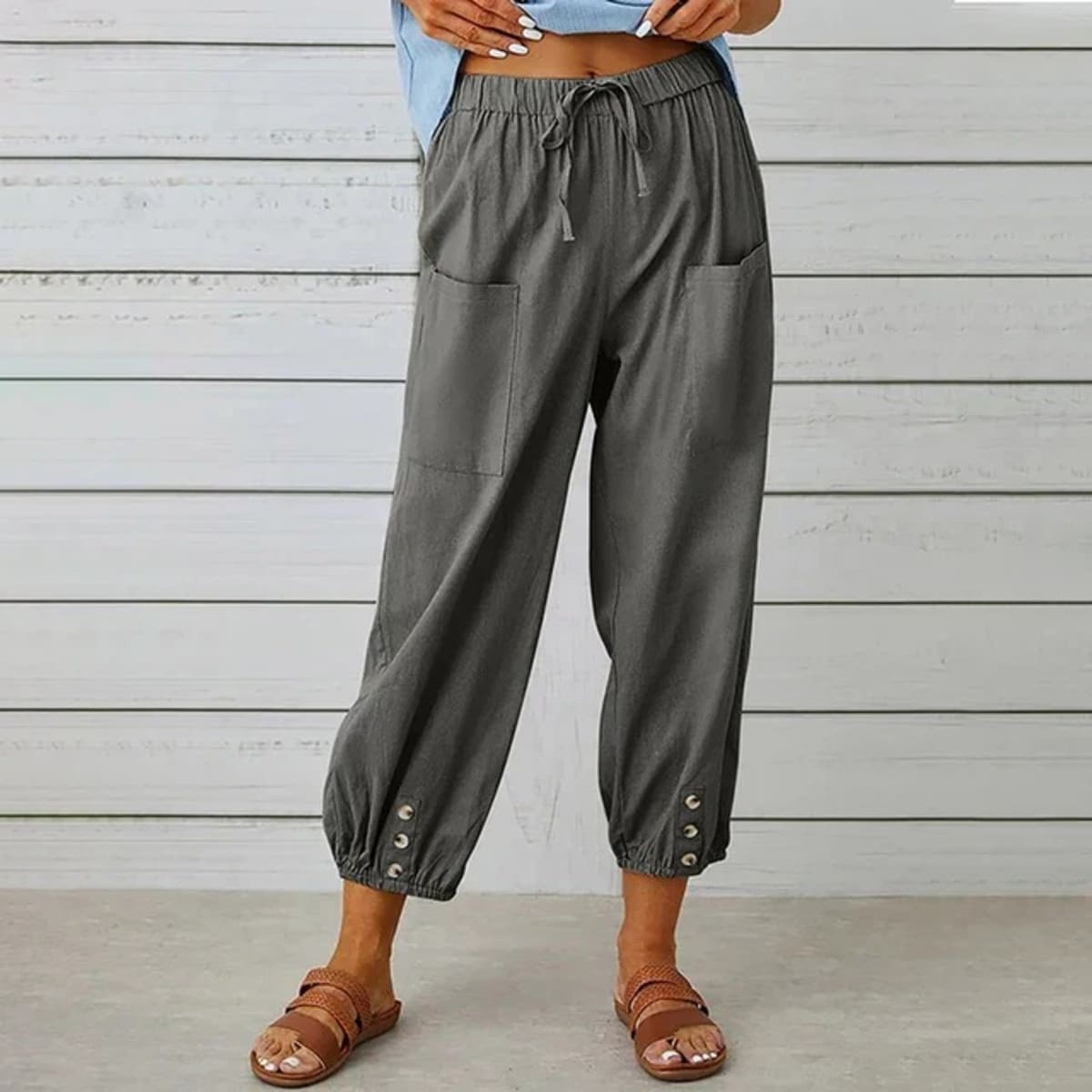 High-waisted relaxed pants with drawstring and ankle buttons.