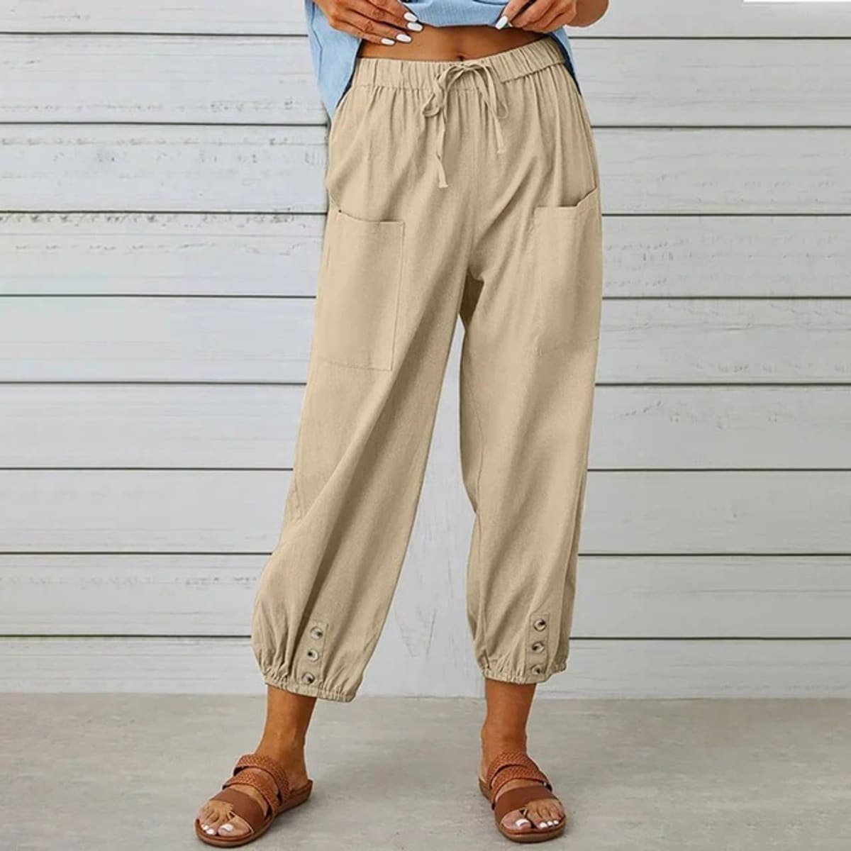 High-waisted relaxed pants with drawstring and ankle buttons.