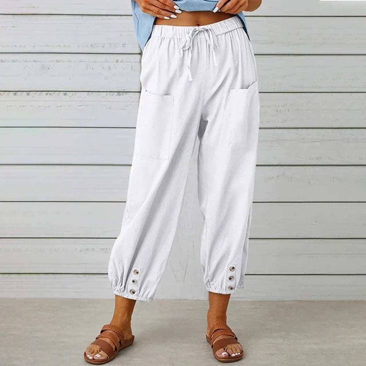 High-waisted relaxed pants with drawstring and ankle buttons.