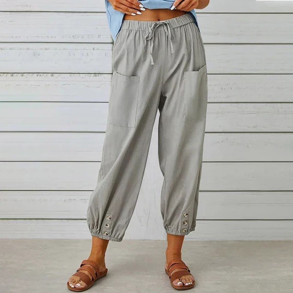 High-waisted relaxed pants with drawstring and ankle buttons.