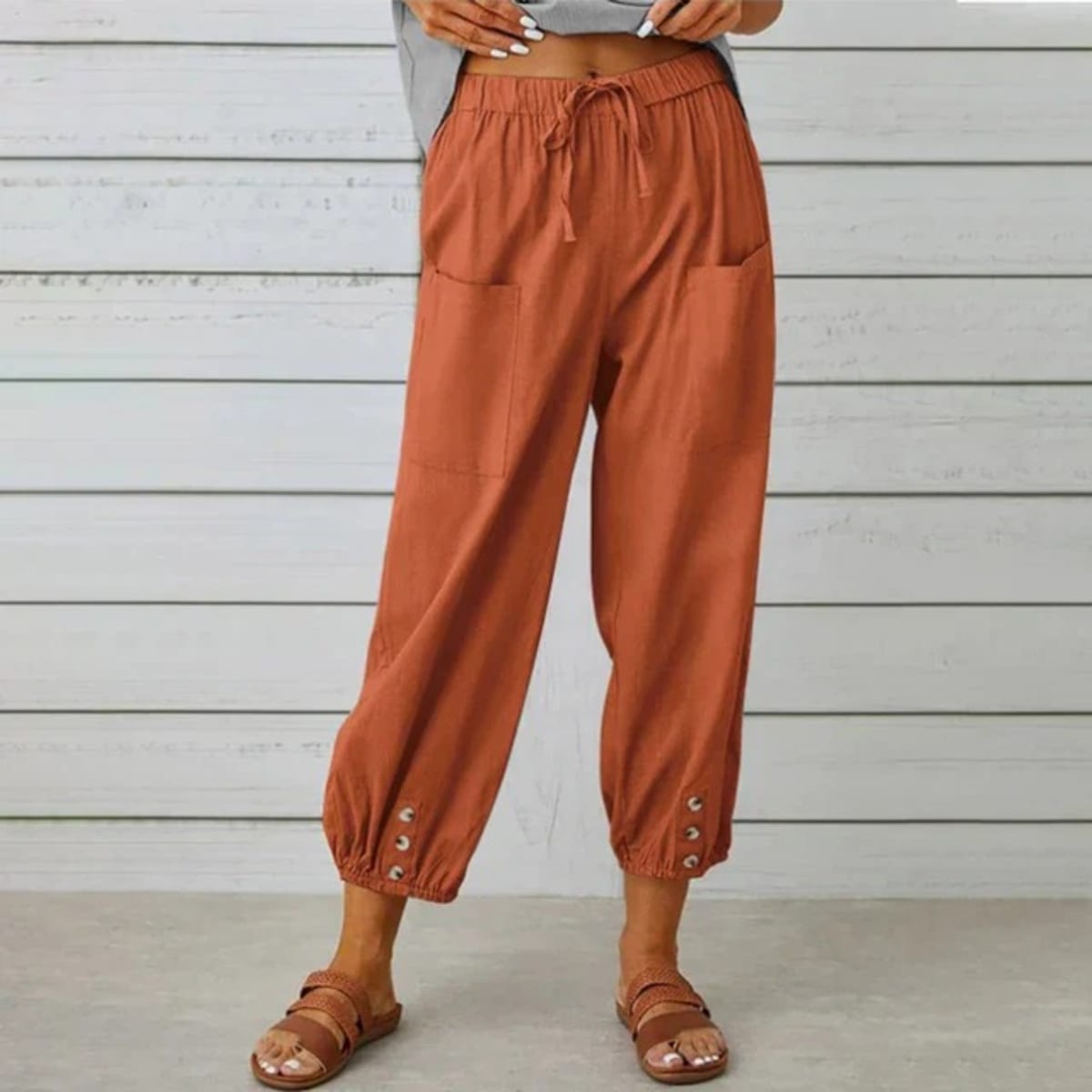 High-waisted relaxed pants with drawstring and ankle buttons.