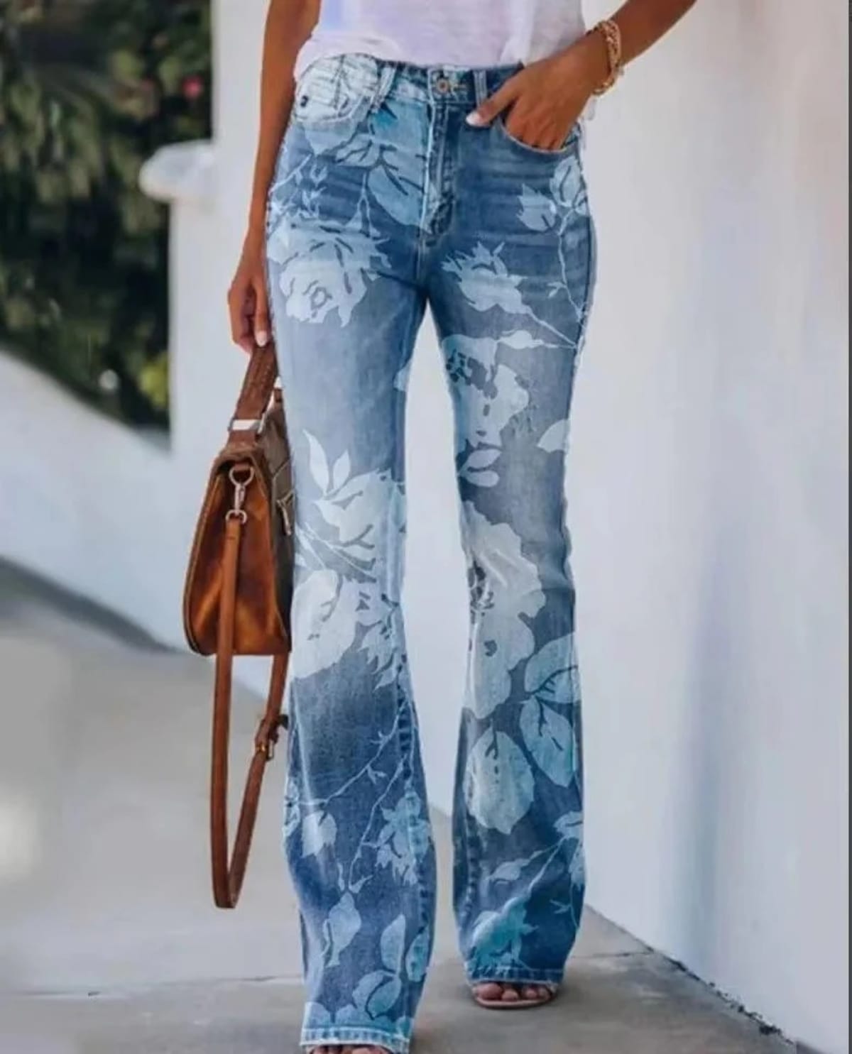 Women's high-waist jeans with floral print and flared hem.