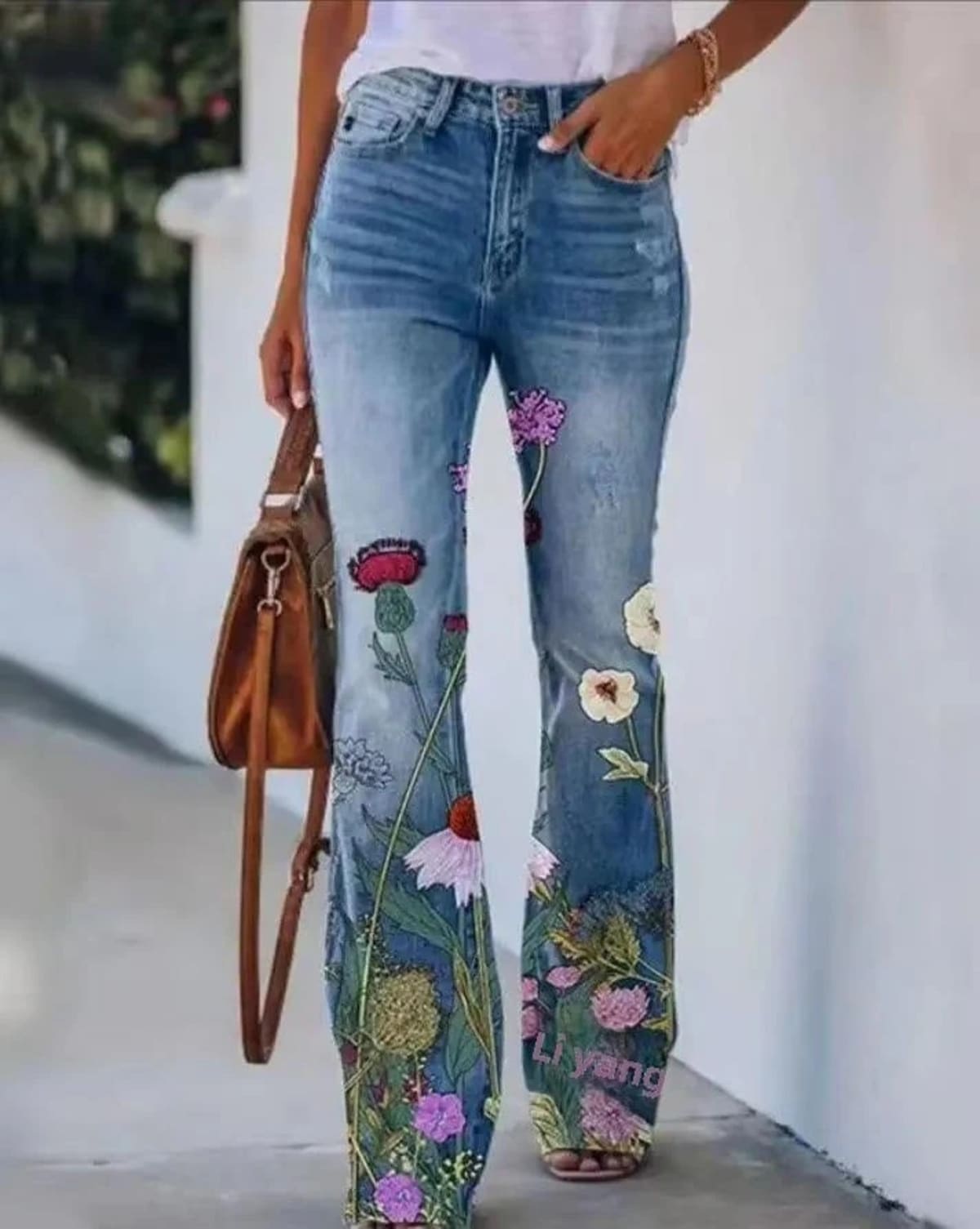Women's high-waist jeans with floral print and flared hem.
