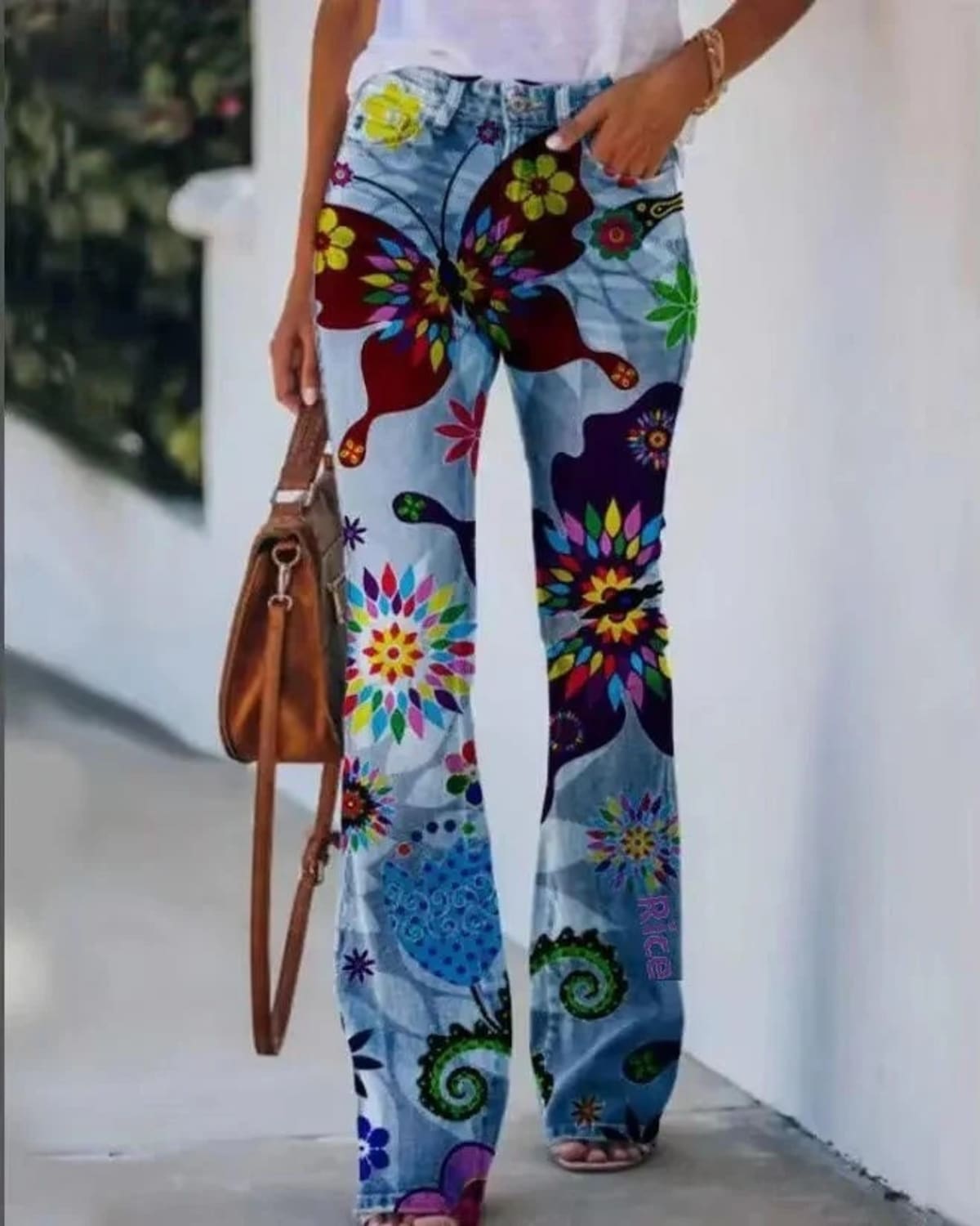 Women's high-waist jeans with floral print and flared hem.