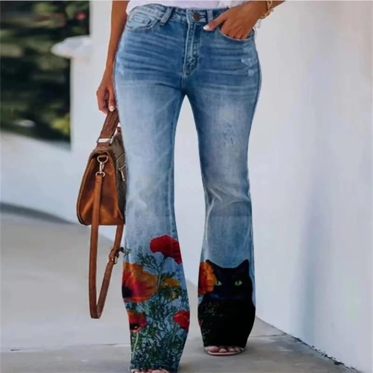Women's high-waist jeans with floral print and flared hem.