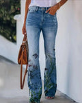 Women's high-waist jeans with floral print and flared hem.