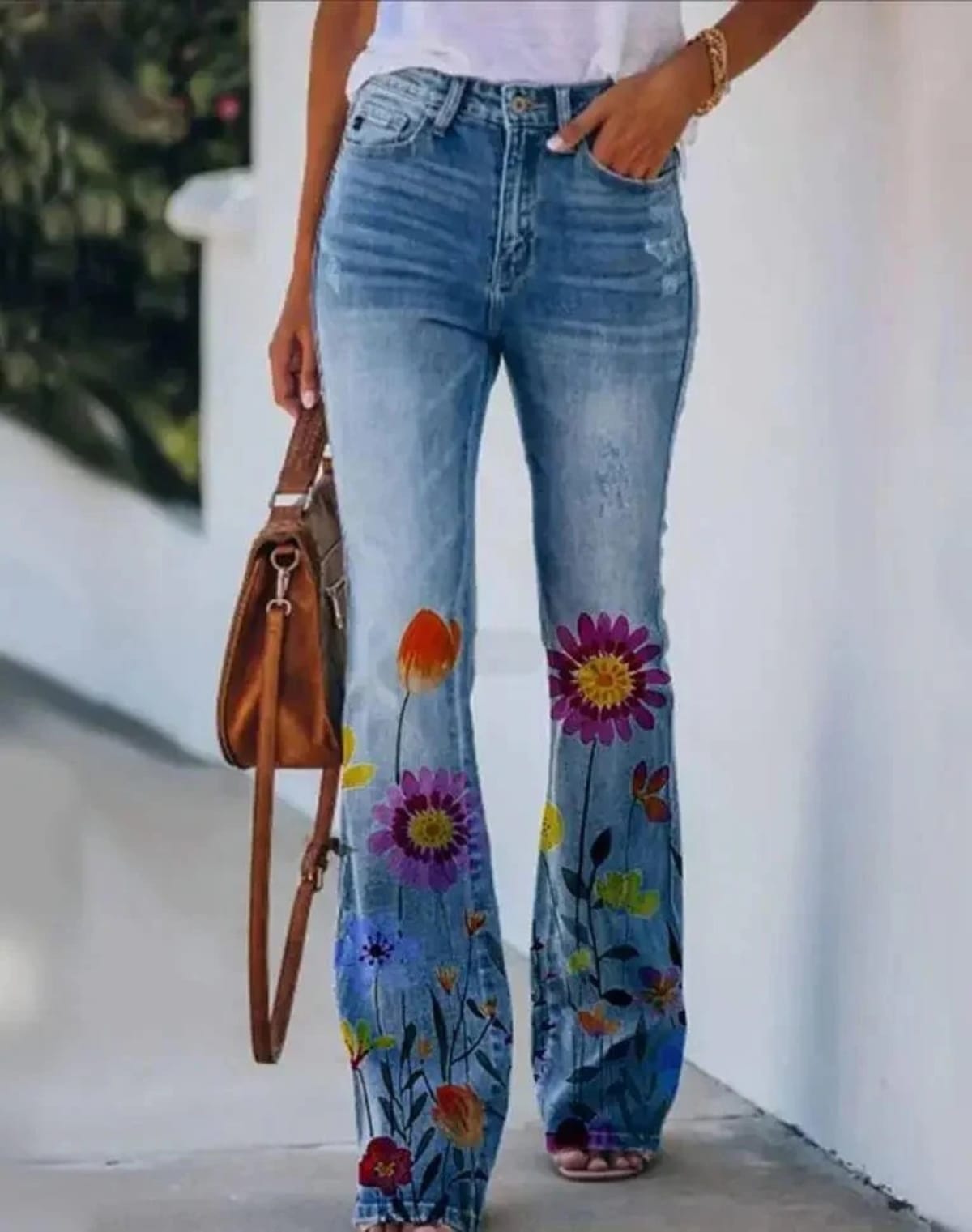 Women's high-waist jeans with floral print and flared hem.
