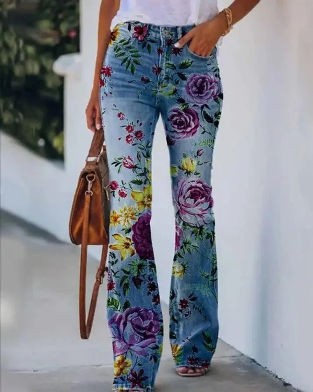 Women's high-waist jeans with floral print and flared hem.