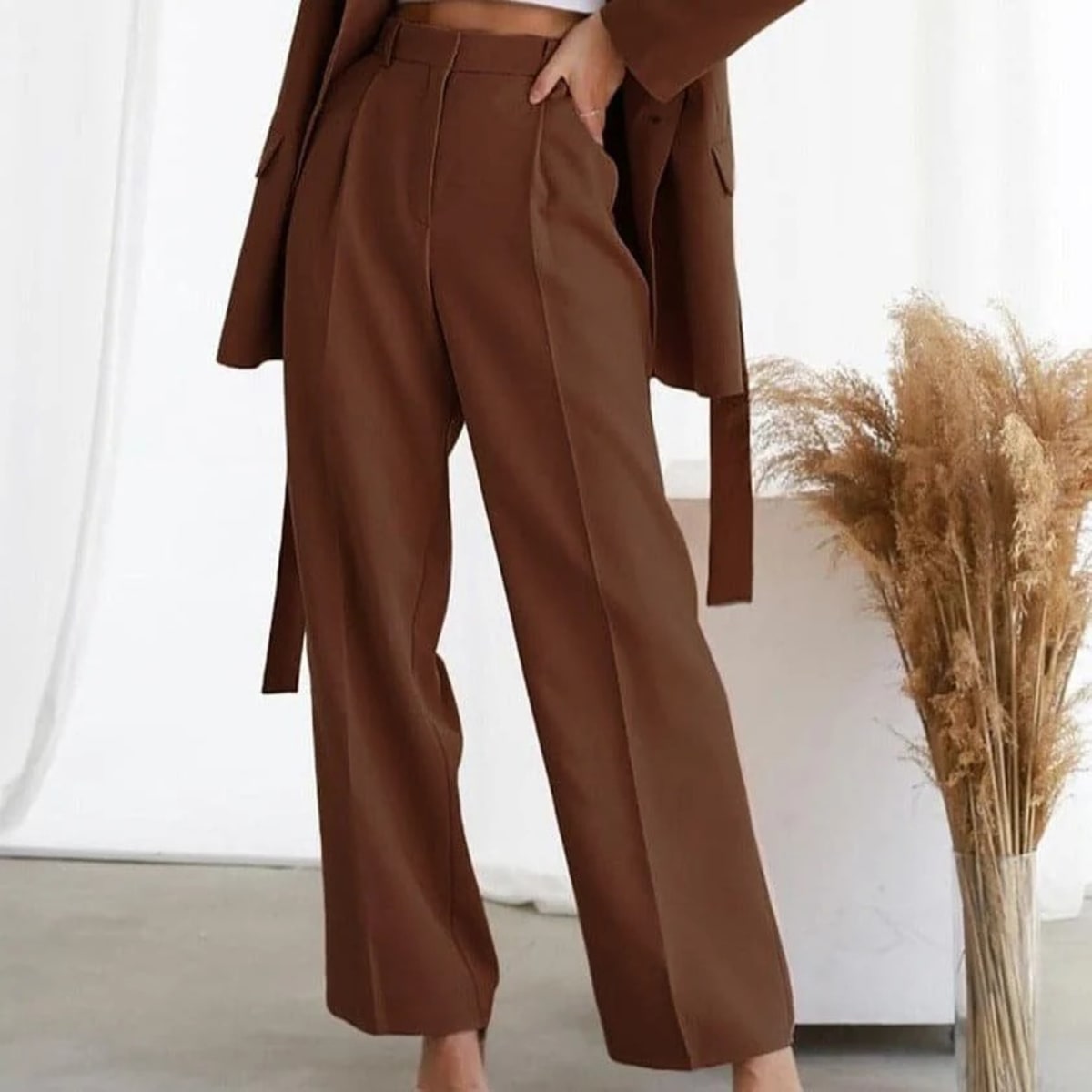 Women's high-waisted wide-leg pants with pleated details.