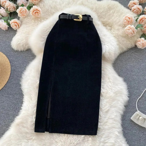 Beige corduroy midi skirt with front slit on white rug.