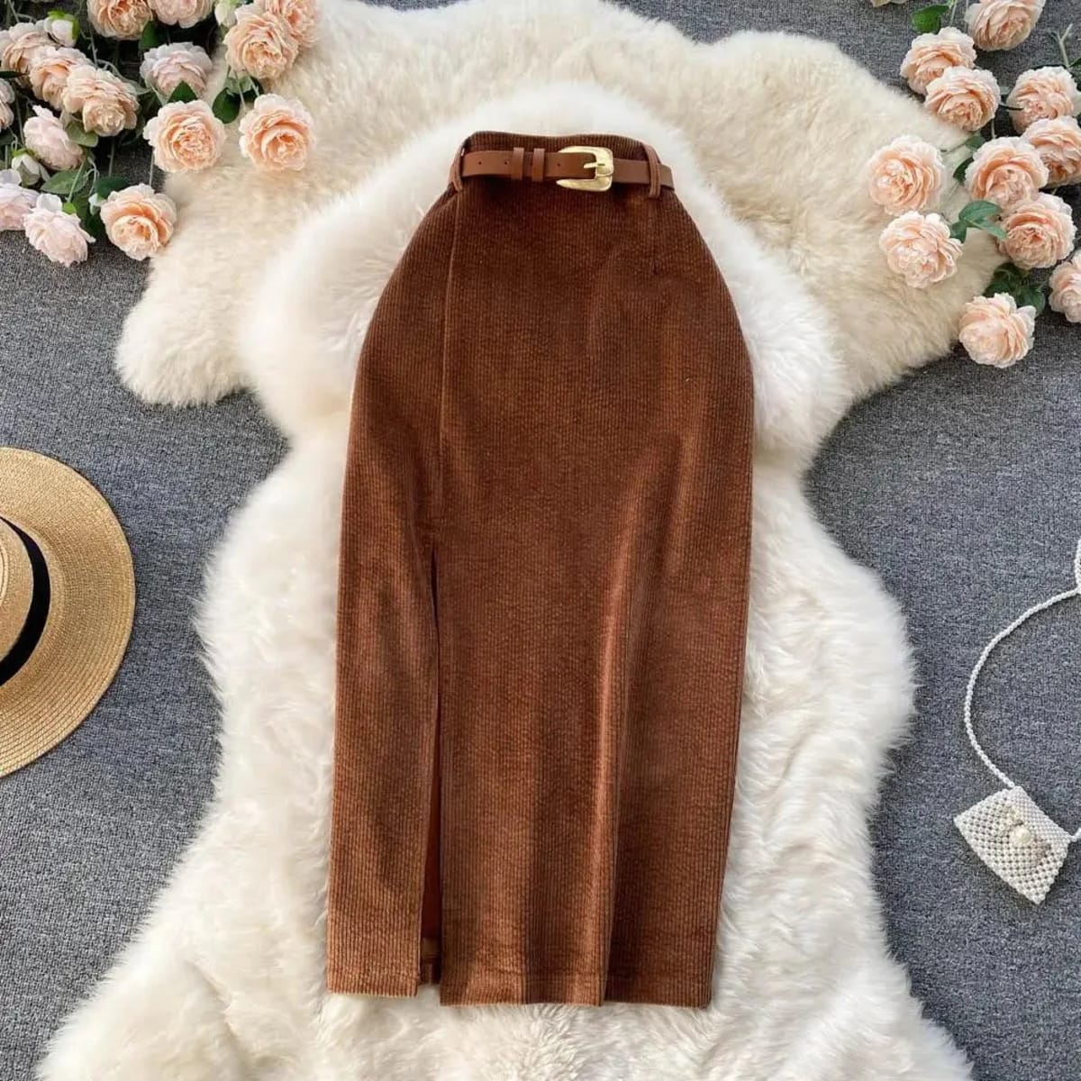 Beige corduroy midi skirt with front slit on white rug.