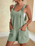 Women's romper with tie-strap shoulders and front pockets.