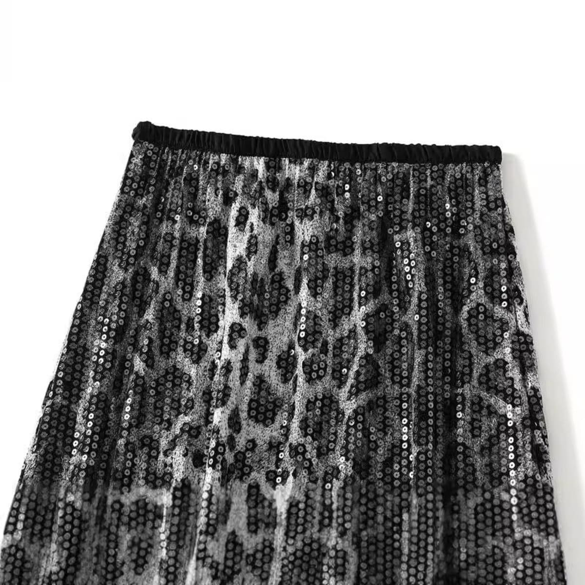 Model in leopard print maxi skirt with crossed arms.