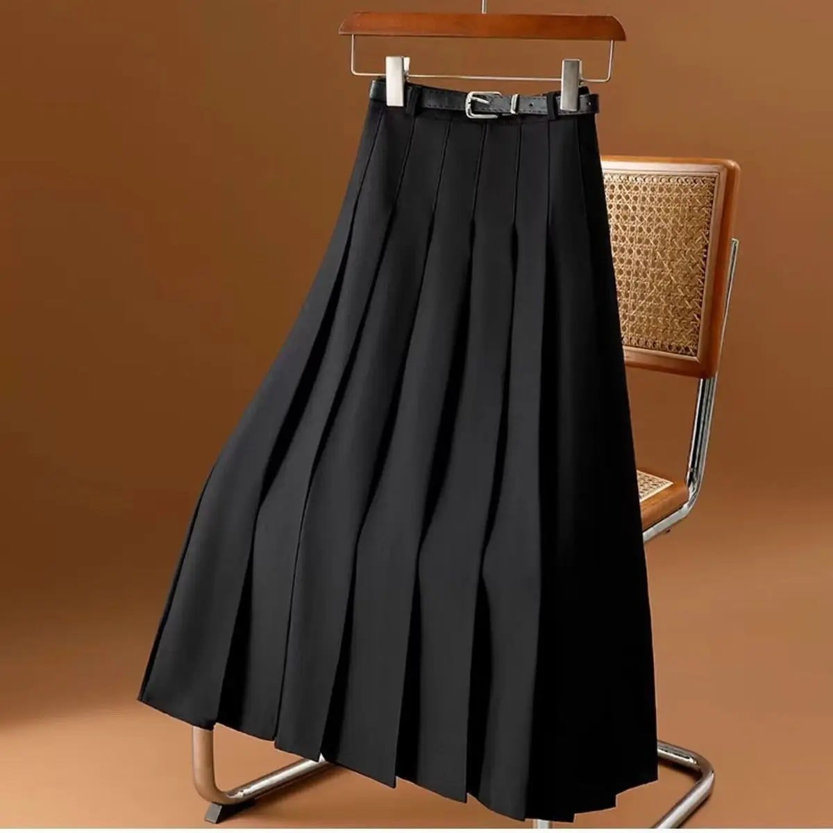 Pleated maxi skirt with belt displayed on a hanger.