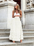 Woman in off-white tiered maxi skirt with ruffles.