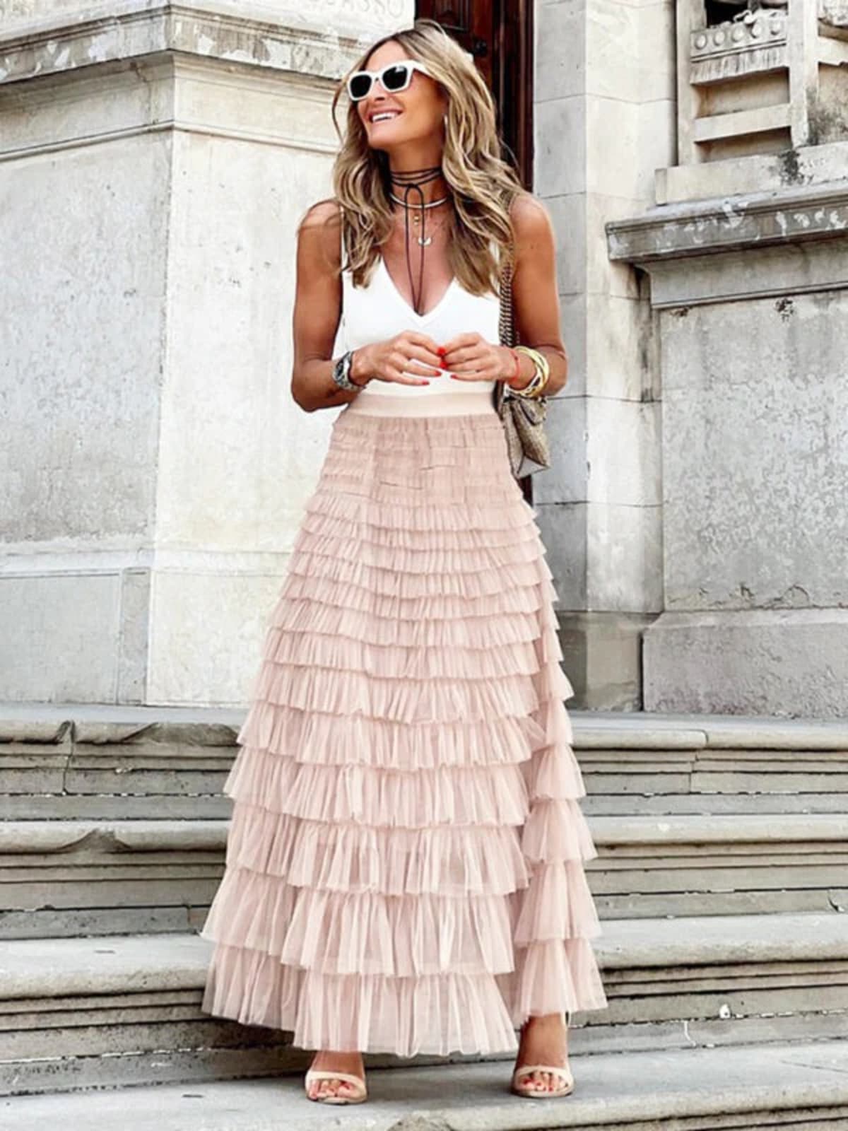 Woman in off-white tiered maxi skirt with ruffles.