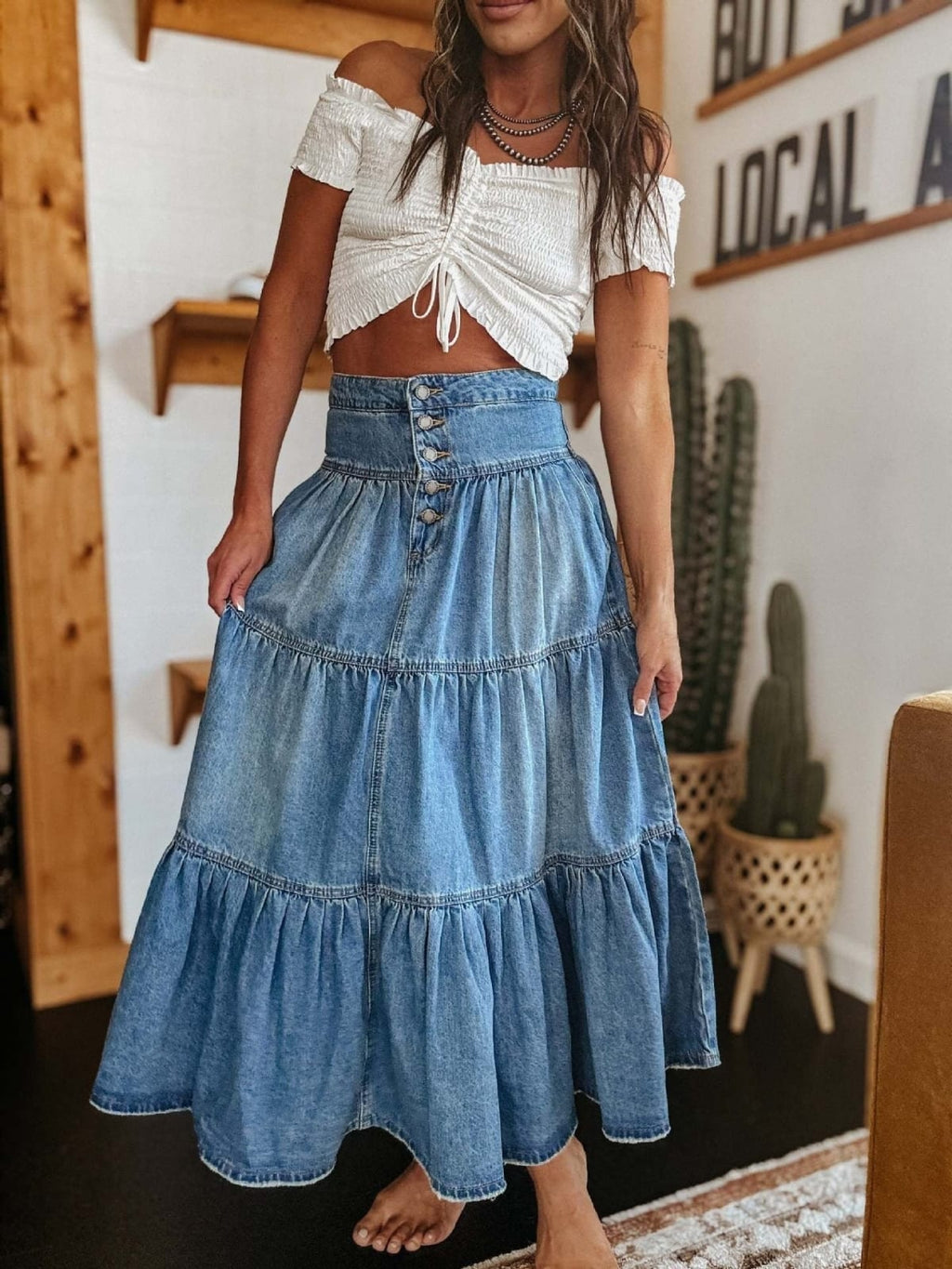 Woman in tiered denim maxi skirt with button-front and off-shoulder top.