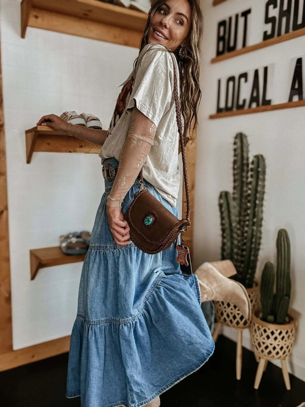 Woman in tiered denim maxi skirt with button-front and off-shoulder top.