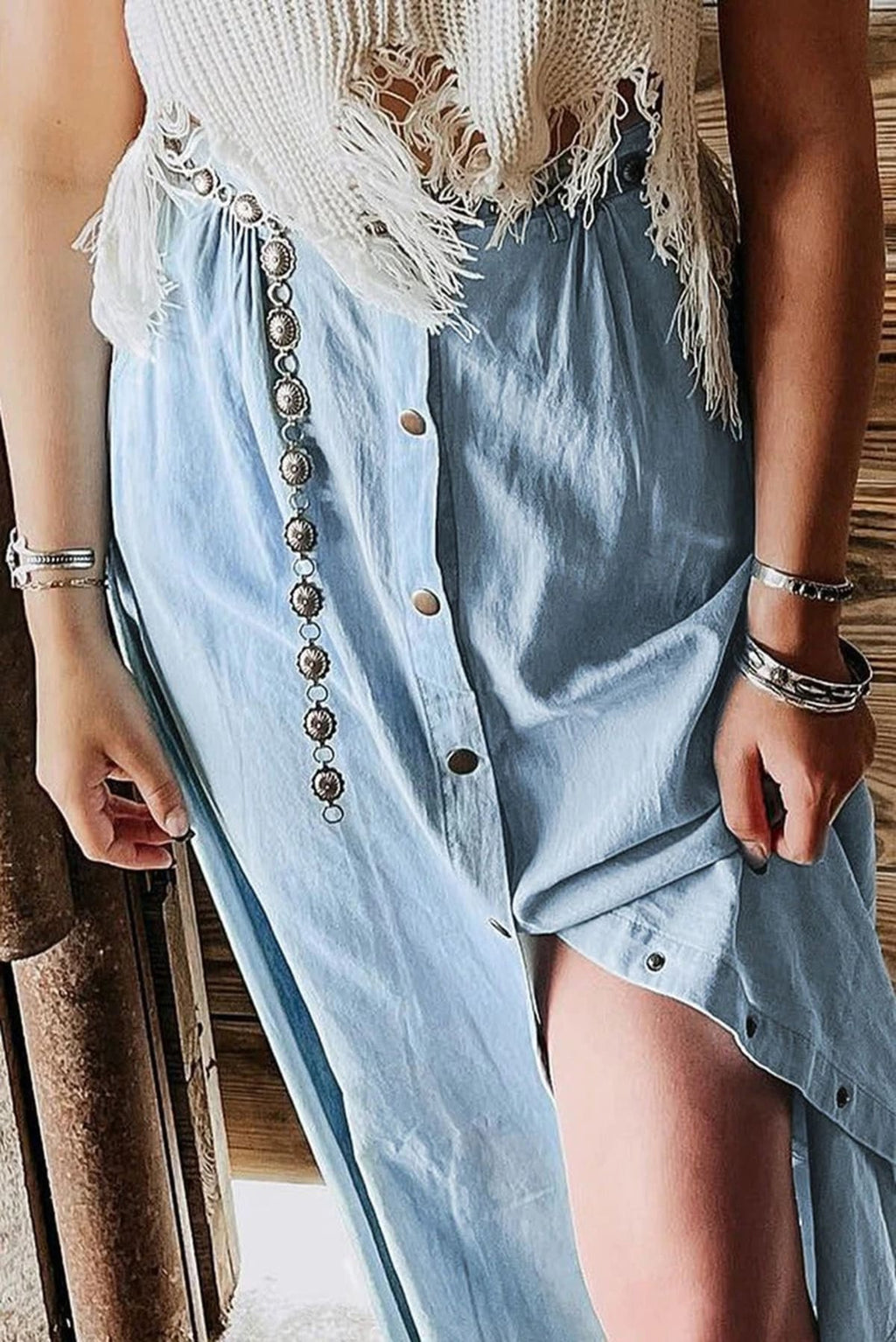 Woman wearing a light blue button-down midi skirt with a front slit.